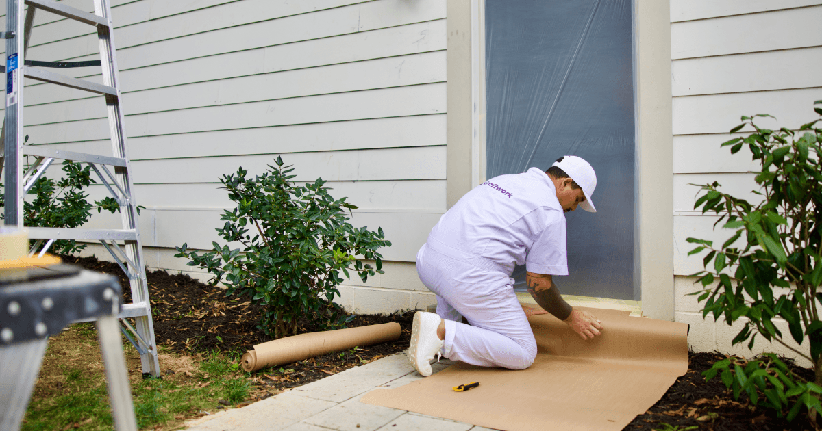 Man cover walkway to home with masking paper