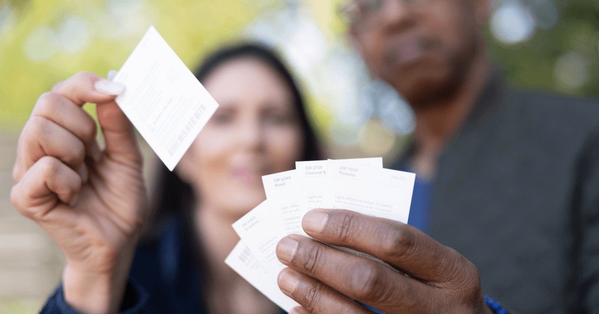 Couple holding up paint swatches to select from 