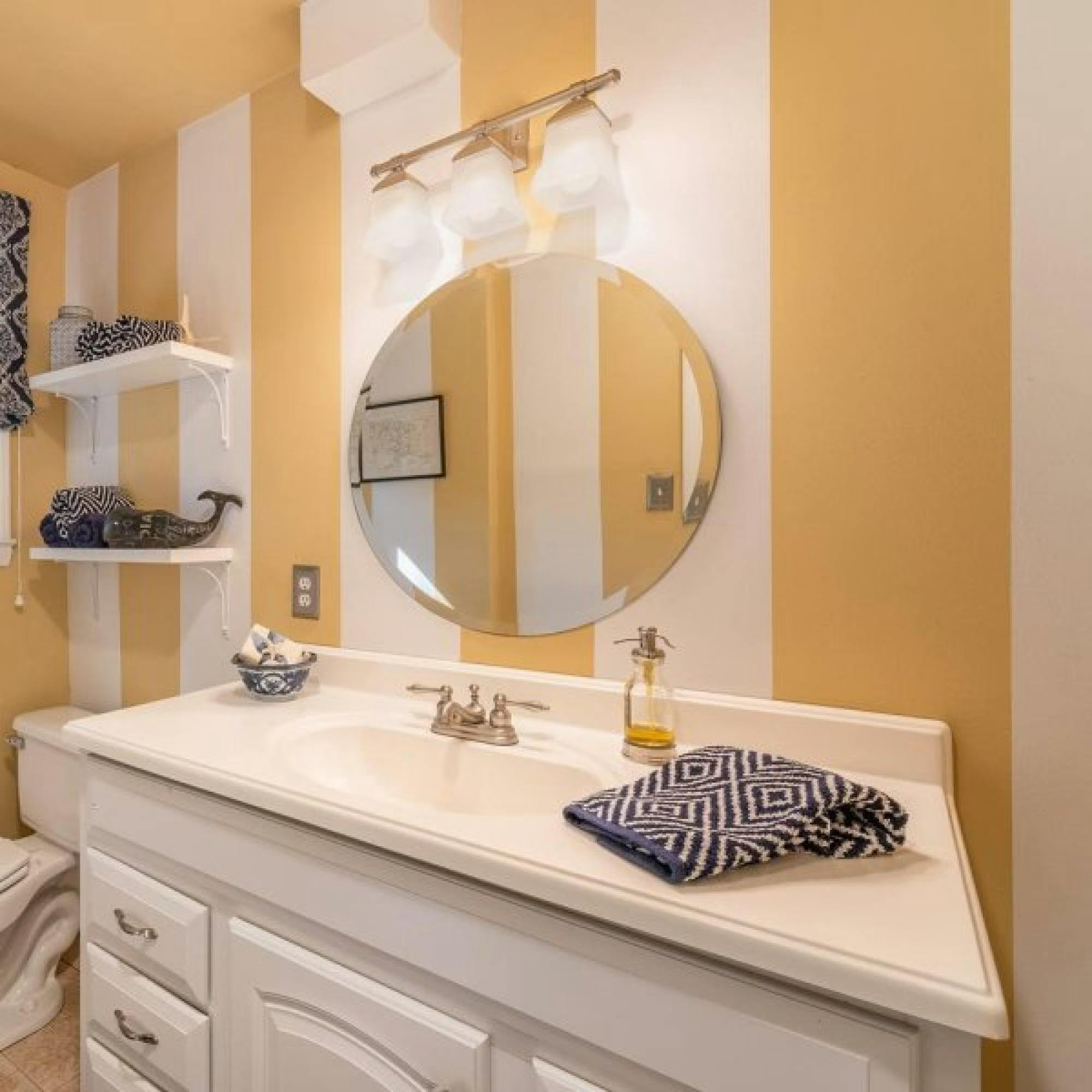 @idccarolinas painted their bathroom with stripes by using Sherwin-Williams, Blonde SW 6128 and Pure White SW 7005.